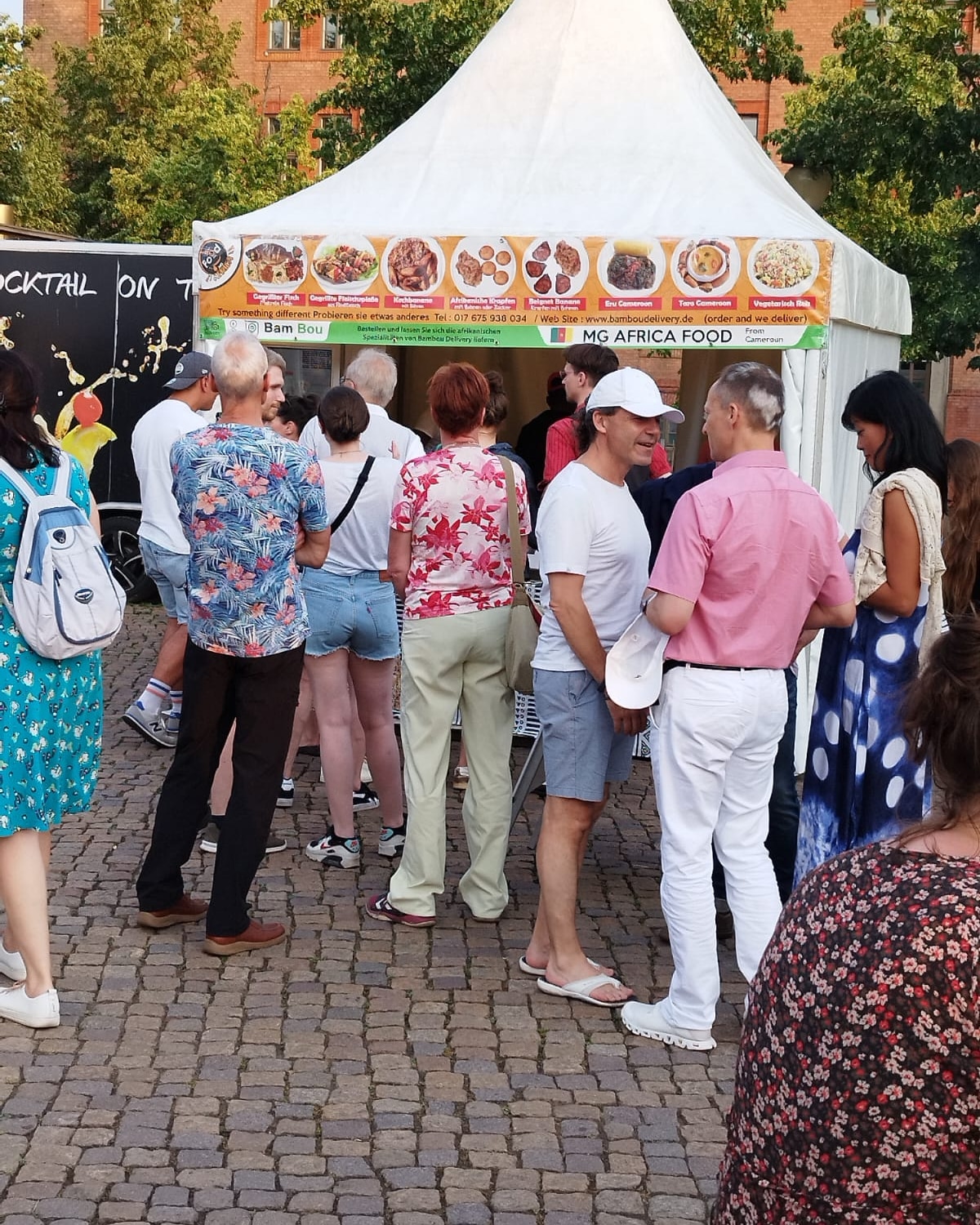 Stand MG Africa Food sur un festival, avec menu et file d'attente
